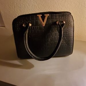 Small black purse, with crocodile design.